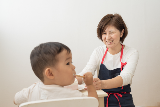 子供にケーキを食べさせる写真